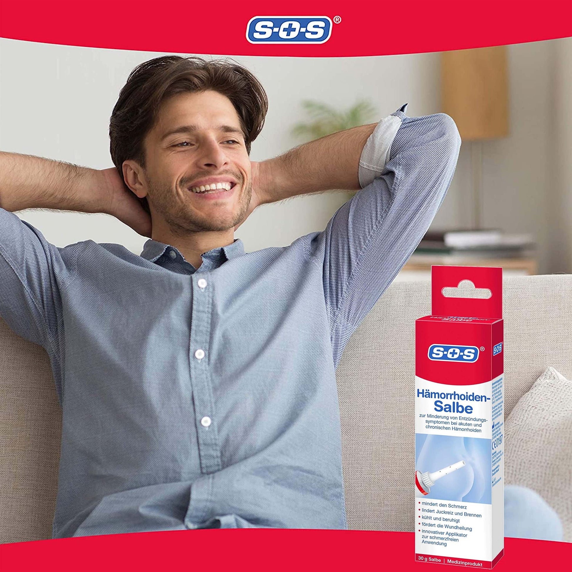 Ein lächelnder Mann entspannt auf einem Sofa, im Vordergrund die rote Produktverpackung "SOS Hämorrhoiden Salbe".