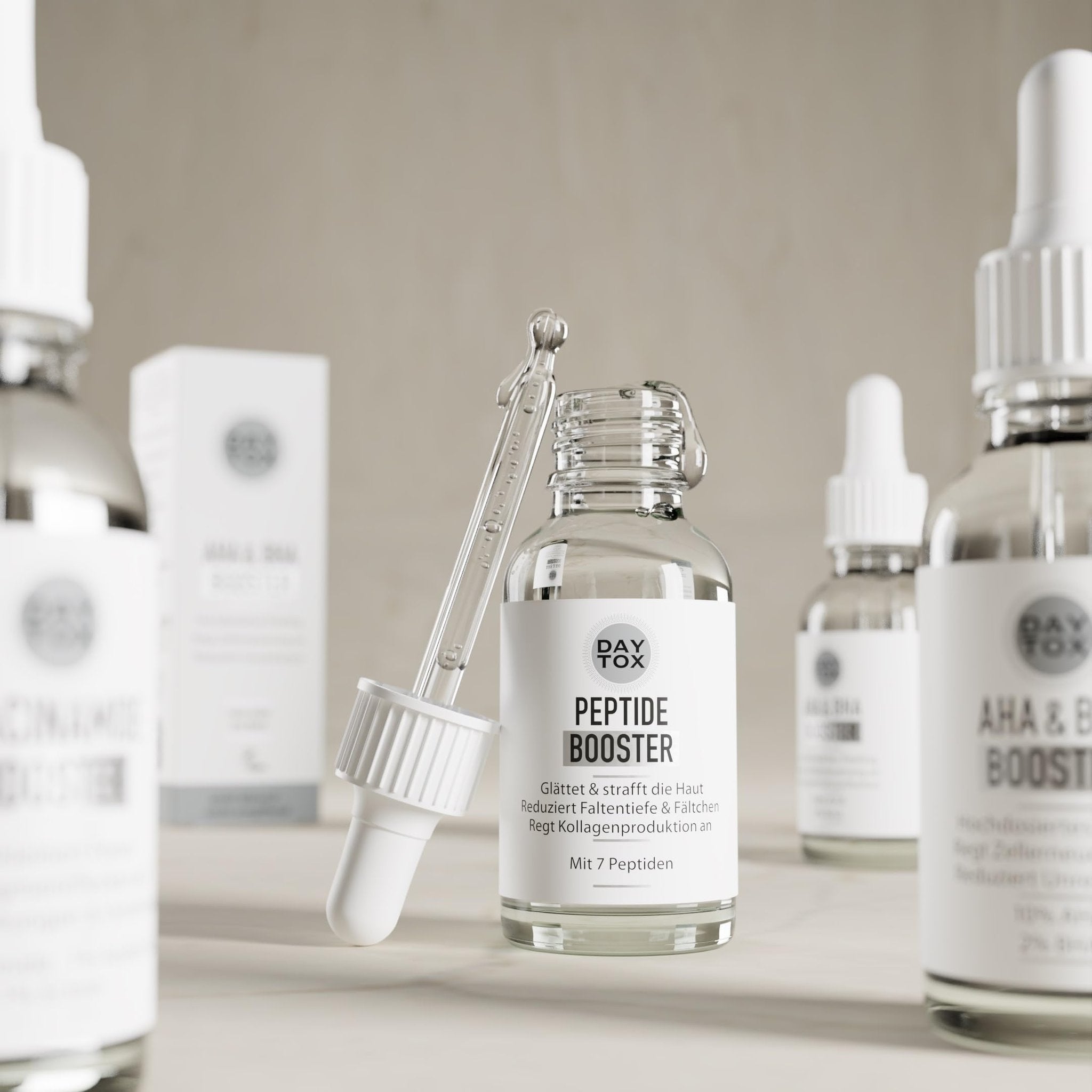 DAYTOX Peptide Booster Flasche mit entfernter Pipette. Im Hintergrund weitere DAYTOX Produkte unscharf.