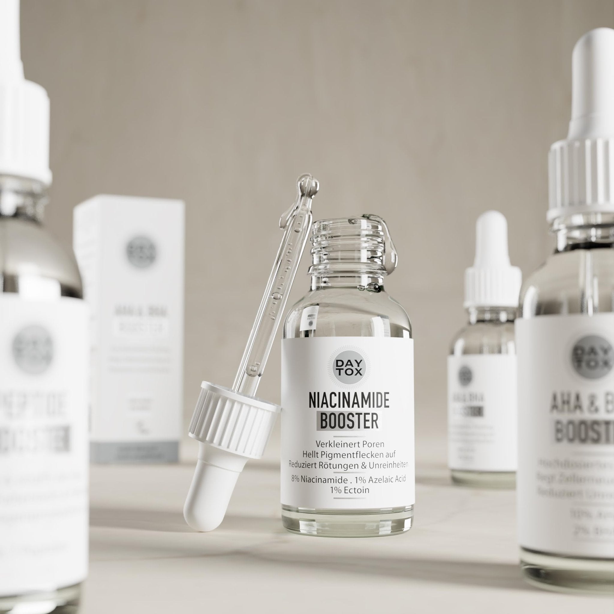 Daytox Niacinamide Booster Flasche mit Pipette in einer Reihe von ähnlichen Produkten auf hellem Tisch.