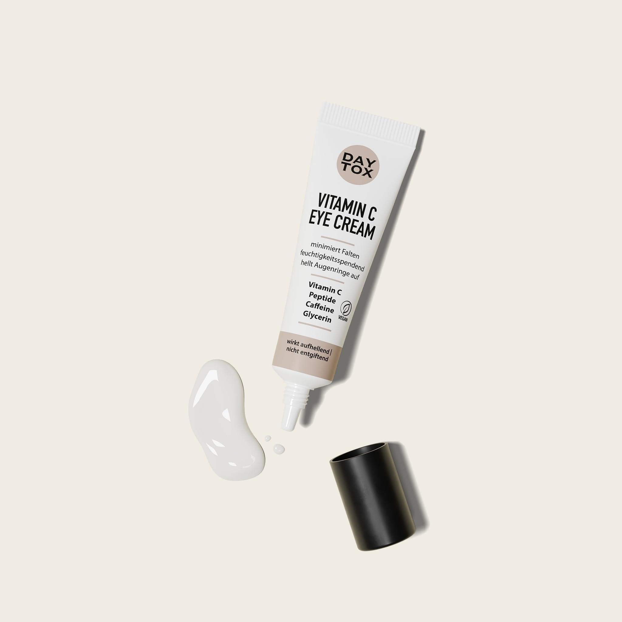 DAYTOX Vitamin C Augencreme Tube mit geöffnetem Deckel und einem Klecks Creme daneben.