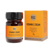 Orangefarbene Produktverpackung und brauner Tiegel der DAYTOX Vitamin C Creme auf weißem Hintergrund.